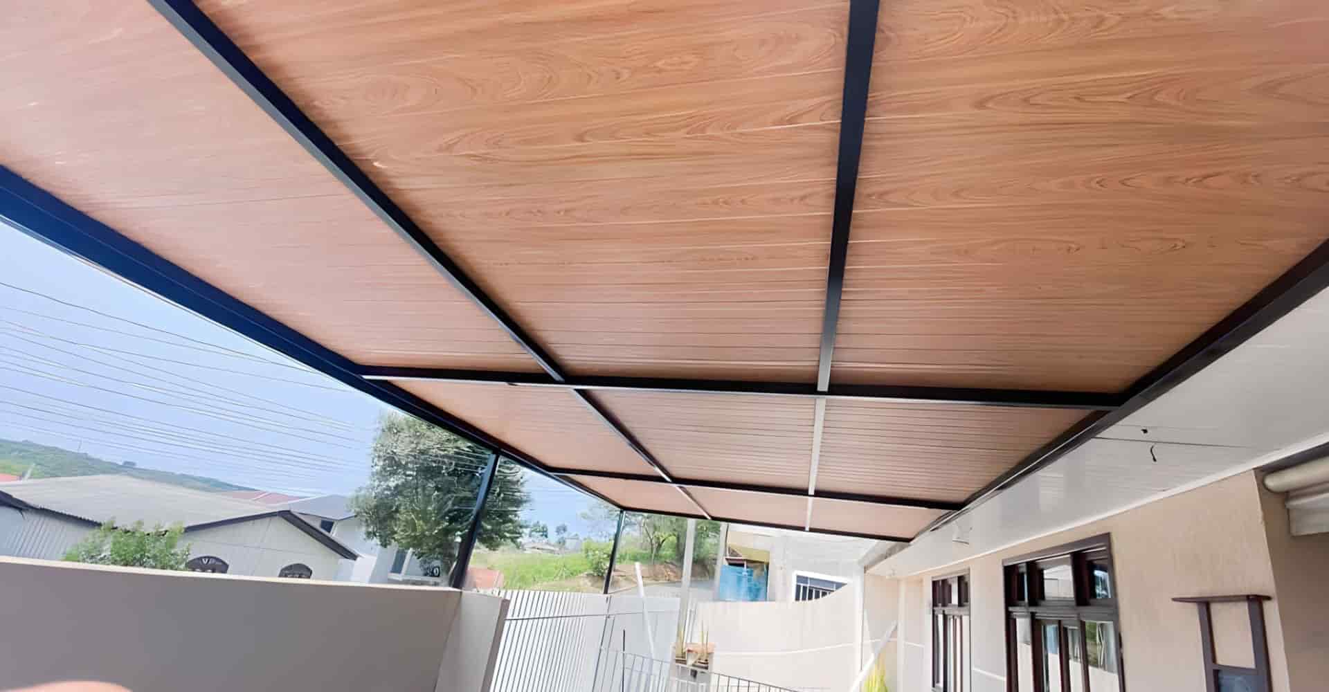 Cobertura de telha forro com face amadeirada instalada em varanda residencial em São Paulo — Toldos Demais