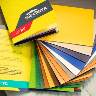 Catálogo visual de lona de vinil para toldo, apresentando variedade de cores e texturas.